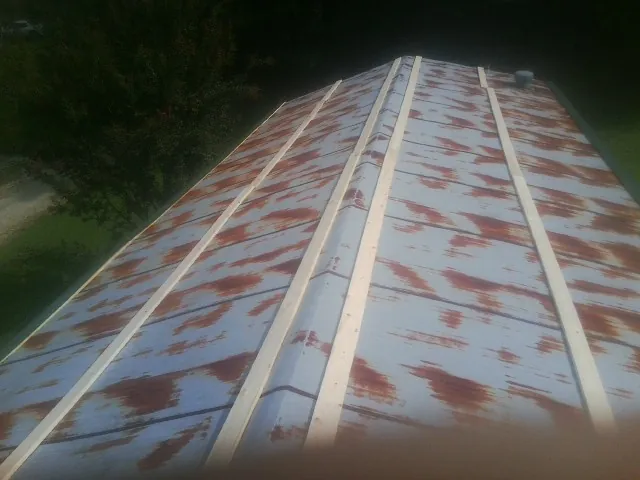 Rusted metal roof panels with new wood purlins before replacement — Storm Damage Roof Repair in Lincoln City by Roofing Brothers