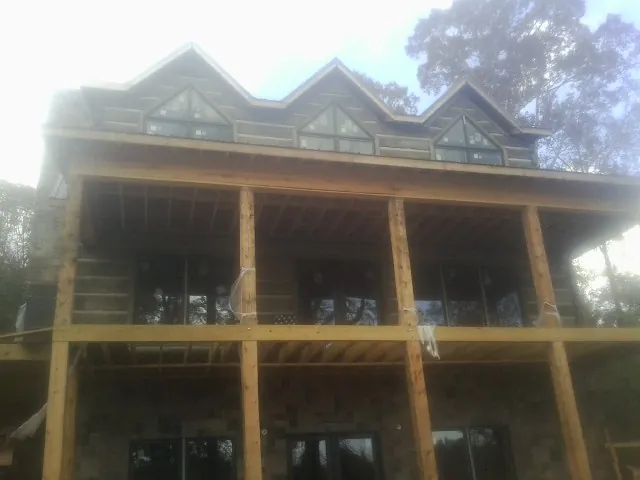 Dormers and porch framing on a large log home under construction — Roof Coating work by our crew in Lincoln City